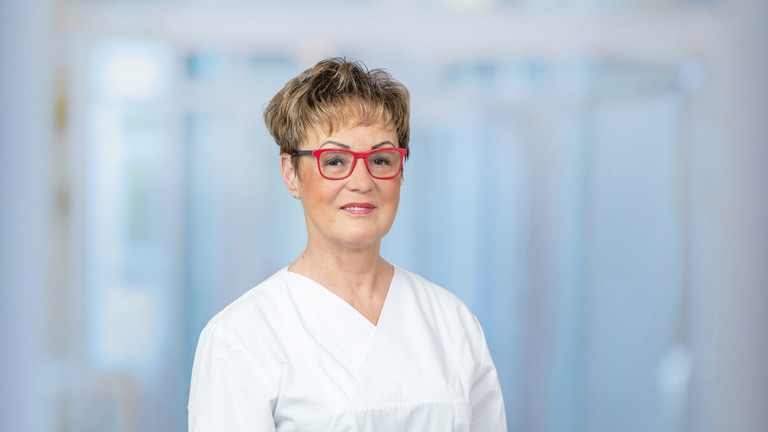 Portraitfoto vor grau-blauem Hintergrund von Marion Baldy, Leitende Hygienefachkraft für die Krankenhäuser und Pflegeeinrichtungen der Immanuel Albertinen Diakonie in Berlin und Brandenburg Portraitfoto vor grau-blauem Hintergrund von Marion Baldy, Leitende Hygienefachkraft für die Krankenhäuser und Pflegeeinrichtungen der Immanuel Albertinen Diakonie in Berlin und Brandenburg