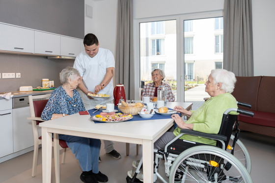 Eine Pflege-Kraft bereitet Frühstück für Bewohnerinnen vor Eine Pflege-Kraft bereitet Frühstück für Bewohnerinnen vor