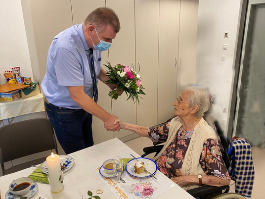 Wustermarks Bürgermeister Holger Schreiber gratuliert Rotraut Meyer zum 100. Geburtstag mit einem Strauß Blumen | Immanuel Seniorenzentrum Elstal